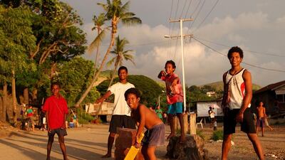 Children from the village of Hanuabada play cricket in the streets in Papua New Guinea. Chris Hyde / Getty Images