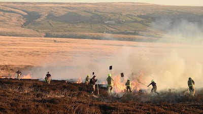 Firefighters tackle a blaze on moorland above Marsden. AFP