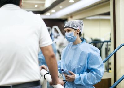 Cornelia Gloor, a physiotherapist, speaks to a patient at RAK Hospital's long Covid rehab centre. Reem Mohammed / The National