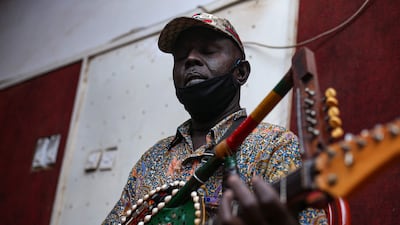 Noureddine Jaber plays a song during rehearsals at a studio in Omdurman, the capital Khartoum's twin city, on May 18, 2022. - Noureddine Jaber, a musician with a unique part-guitar, part-tamboura instrument, is giving voice to Sudan's long-marginalised eastern communities through a new album. Hailing from the Red Sea city of Port Sudan, Jaber belongs to the Beja people, a group of nomadic herders and breeders with unique languages, culture, food and music. (Photo by Median Yasser / AFP)