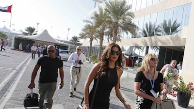 Singer Nicole Scherzinger, front centre, girlfriend of Mercedes Formula One driver Lewis Hamilton and his father, Anthony, left, arrive at Yas Marina Circuit. Hamad I Mohammed / Reuters