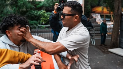 A pro-regime counter-protester scratches the face of a demonstrator taking part in a Free Iran rally outside the UN General Assembly in New York, US. AFP