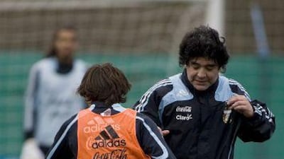 Lionel Messi swerves past his coach, Diego Maradona, during training for tomorrow's World Cup match against Brazil.
