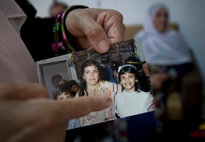 Fadwa Tlaib, an aunt of Rashida Tlaib, points to a young Rashida in a 1987 picture with her mother Fatima and brother Nader, at the family house, in the West Bank village of Beit Ur al-Foqa. Nasser Nasser / AP