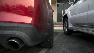 A car stands parked haphazardly, crossing into the next parking spot, near a grocery store in Abu Dhabi. Silvia Razgova / The National