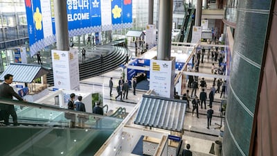 Attendees walk past booths at the IATA annual general meeting in Seoul, South Korea. Bloomberg
