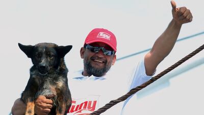 A member of the crew of the Mexican tuna vessel "Maria Delia" poses for a picture with "Bella", Australian sailor Tim Shaddock's dog, after arriving at the port of Manzanillo, Colima State, on July 18, 2023. An Australian sailor and his dog were rescued after more than two months adrift in the Pacific Ocean, surviving the ordeal by drinking rainwater and snacking on raw fish. Shaddock and his dog Bella set off in a catamaran from Mexico's seaside city of La Paz in April, and planned to sail about 6,000 kilometres (3,700 miles) before dropping anchor in tropical French Polynesia. (Photo by ULISES RUIZ / AFP)