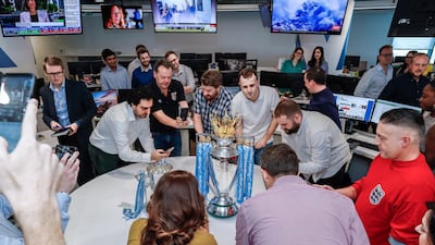 The Premier League trophy and Carabao Cup visit The National newsroom.