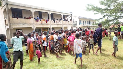 People gather outside a hall in Madagascar after the cyclone, which packed winds of about 130kph, passed. AFP