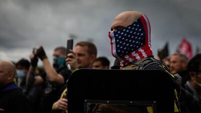 A man hold his hand to his heart as a Proud Boys organiser recites the Pledge of Allegiance during a rally by the far-right group in Delta Park in Portland, Oregon, on September 26, 2020. AFP