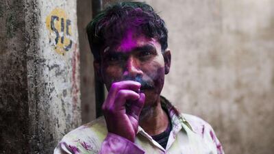 An Indian youth takes a break from festivities to have a cigarette in a alleyway in New Delhi. Andrew Caballero-Reynolds / AFP Photo