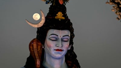 The moon rises behind an idol of the Hindu god Shiva in Ahmedabad, India, on the eve of the Wolf supermoon. AFP