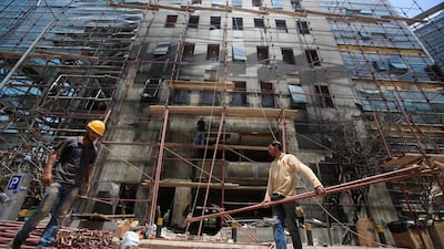 Workers repair the facade of the headquarters of the Lebanese Blom Bank that was struck by a bomb last week. Jamal Saidi / Reuters