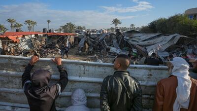 Palestinians survey the aftermath of an Israeli army air strike on Wednesday at Al Muwassi camp for displaced people near Khan Younis. AP