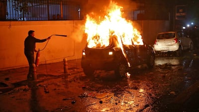 A man tries to extinguish a burning car after demonstrators set it on fire during a protest against a new citizenship law, in New Delhi, India, December 20, 2019. REUTERS/Stringer