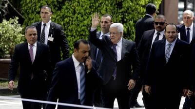 Palestinian President Mahmoud Abbas, center, is surrounded by bodyguards as he greets reporters upon his arrival to attend a meeting with Arab foreign ministers meeting at the League's headquarters in Cairo on April 9. Amr Nabil / AP Photo