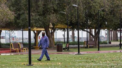 A municipal worker walks in a closed park in Jumeirah with his face covered. Antonie Robertson / The National