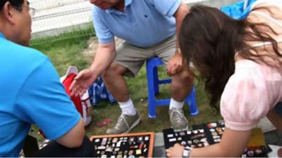 Ross Baxter, centre, from Scotland travels to every Olympic Games to trade or swap Olympics-related pins.