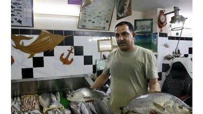 The owner, Moneer Abu Hassira, showcases the latest catch in his restaurant's fish market.