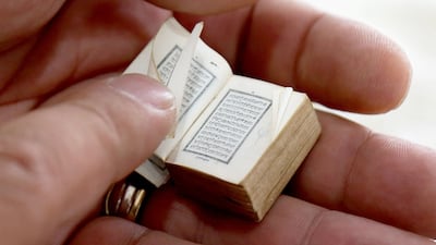 Mario Prushi holds in his hand one of the smallest Koran (Islam's holy book), of a postage-stamp size with a cover crafted from gold embroidered velvet, in Tirana, Albania, on April 17, 2023. - The ritual is always the same. Mario Prushi carefully washes his hands and face before kissing and pressing one of the world’s smallest Korans to his forehead. For generations, the postage-stamp sized book has been passed down in his family -- surviving authoritarian governments, war, and the perils of time. (Photo by Adnan Beci / AFP)