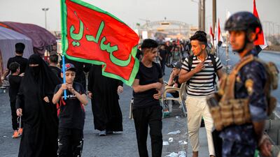 A policeman stands guard as Shiite pilgrims march from Iraq's capital Baghdad on their way to Karbala. AFP