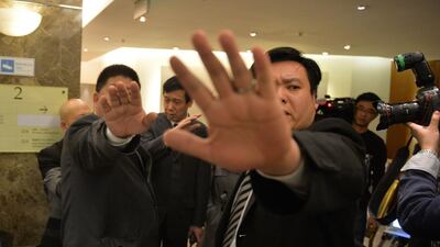 Chinese security guards block photos of a man trying to hand out leaflets to journalists with his theory about the missing Malaysia Airlines flight MH370 at a hotel in Beijing. At their first meeting, Chinese relatives of the missing passengers accused Malaysian officials of wasting time. Mark Ralston / AFP / March 21, 2014.