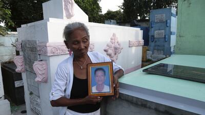 Elvira Miranda holds up a picture of her son Leover, who was killed by the anti-drugs police in the Manila cemetery where he lived. Mrs Miranda denies that her son was involved in drugs. Florian Neuhof for The National