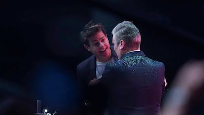 The pair engage in conversation. PA