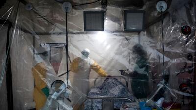 Three medical workers check on an Ebola patient in a Biosecure Emergency care Unite (CUBE) on August 15, 2018 in Beni. AFP