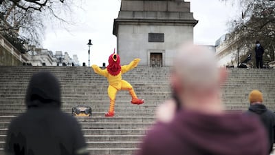 A person dressed in a chicken costume dances to music on Good Friday in London. Reuters
