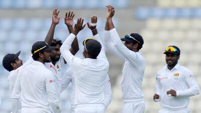 Sri Lankan's Nuwan Pradeep, centre, celebrates with teammates the dismissal of Ahmed Shehzad. Lakruwan Wanniarachchi / AFP / July 4, 2015