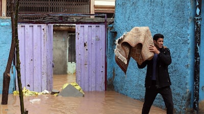 An Iranian man carries a carpet from his flooded home in the city of Khorramabad, Lorestan Province, western Iran. EPA