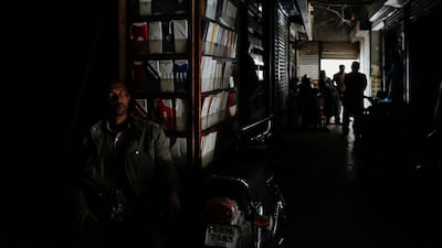 A shopkeeper sits in near-darkness in Karachi. The blackout raised questions about the government's handling of the situation. Reuters
