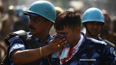 An injured policeman receives help during a protest in Prayagraj. Reuters