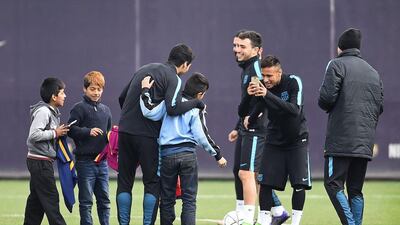 Neymar of FC Barcelona takes photographs of Luis Suarez of FC Barcelona with young fans who ran onto the training pitch during a Barcelona training session ahead of the Uefa Champions League round of 16 second leg match between Barcelona and Arsenal at Ciutat Esportiva on March 15, 2016 in Barcelona, Spain. (Photo by David Ramos/Getty Images)