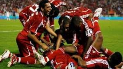 Oman's jubilant players swamp Rabia after one of his three strikes.