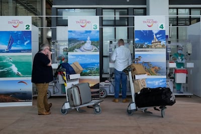 Tourists prepare for a Covid-19 swab test after arriving in Phuket, southern Thailand. AP Photo / Sakchai Lalit