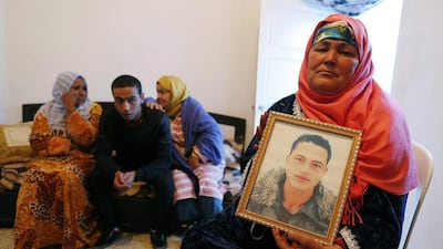 Nour Al Houda (R), 65, poses with a portrait of her son Anis Amri at her home in Oueslatia, Tunisia, on December 22, 2016. Mohamed Messra/EPA