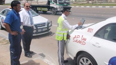 A Saaed accident officer files a report at an accident scene.
