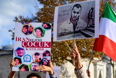 Protesters in Istanbul with placards featuring Iranian rapper Toomaj Salehi and children killed in demonstrations in Iran. AFP