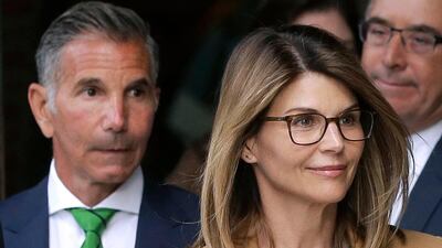Actress Lori Loughlin, front, and husband, clothing designer Mossimo Giannulli, left, have been sentenced for their roles in a college admissions scandal. AP photo