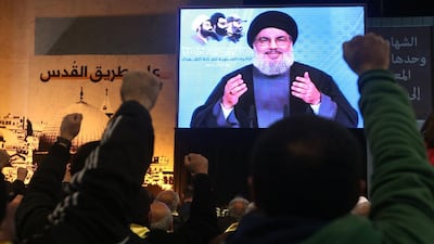 Supporters raise their hands and shout slogans as Hizbollah's leader Sheikh Hassan Nasrallah addresses them via a video link in the southern suburbs of Beirut, Lebanon on February 16, 2015. Hussein Malla/AP Photo