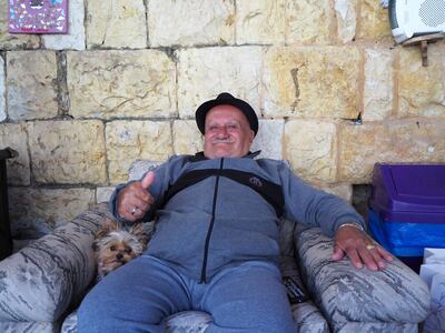A resident of Beit Judoodna reclines with a canine companion. Emily Lewis for The National