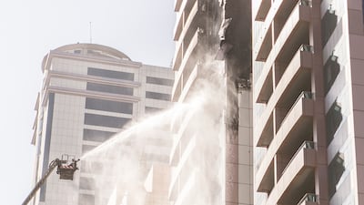 Fire crews extinguish a tower block blaze in Sharjah. The National