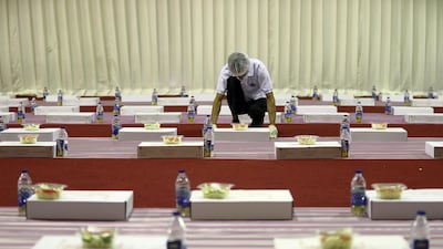 A worker arranges food packets for iftar on the first day of Ramadan at the Sheikh Zayed Grand Mosque in Abu Dhabi. Pawan Singh / The National