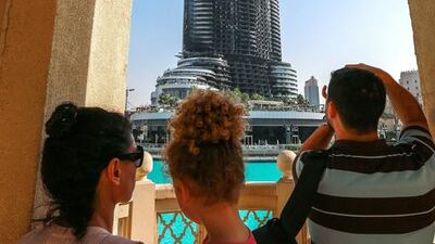 Passersby take photos of the damaged building.