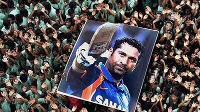 FOR USE AS DESIRED, YEAR END PHOTOS - FILE - In this March 16, 2012 file photo, Indian students hold a large poster of Indian cricketer Sachin Tendulkar after Tendulkar batted for his landmark 100th century, at a school in Chennai, southern India. Tendulkar, who had been stuck on 99 centuries for a year, became the first cricketer to score 100 international centuries when he hit to square leg and ran a single against Bangladesh in the Asia Cup. (AP Photo/File) INDIA OUT