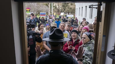 Attendees at a rally against vaccine and mask mandates on February 1 argue with Oregon state troopers in Salem, Oregon. AFP