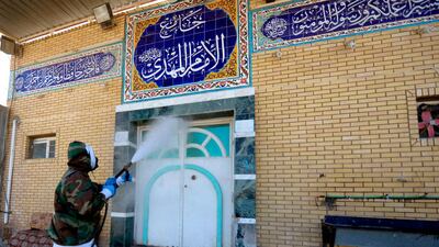 A member of the Iraqi civil defence disinfects the entrance of a mosque in the central shrine city of Najaf. AFP
