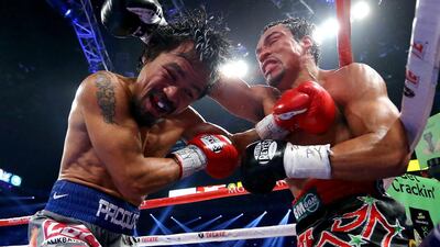 Manny Pacquiao, left, and Juan Manuel Marquez, right, exchange blows during their welterweight bout. Al Bello / Getty Images